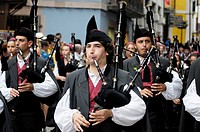Parade of pipe bands through the streets of Llanes during the festival of San Roque, Llanes, Asturias, Spain.