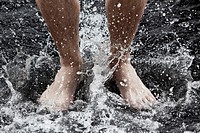man feet in the shower under the streams of water