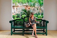 Woman sitting on bench looking at map, Bermuda Island, Atlantic