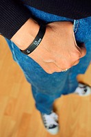 Woman in blue jeans, black sweater and sneakers, wearing a ´Lens Bracelet´ designed by Adam Elmakais - with shallow depth of field