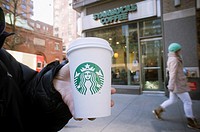 A Starbucks coffee cup with their new sans-typography logo is seen in Midtown Manhattan in New York Starbucks has rolled out its new logo, notably rem...