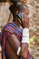 Maasai man wearing traditional dress and using modern smart phone.