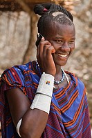 Maasai man wearing traditional dress and using modern smart phone.
