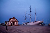 sunset over the harbor and the three-mast barque Gorch Fock 1 in the Hanseatic City of Stralsund, Mecklenburg-Vorpommern, Germany