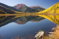 Rocky Mountain foliage reflects in a clear mountain lake