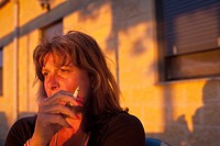 Woman relaxing in the evening sunlight with a cigarette