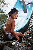 Guatemala, Mayan girl with dug out canoe