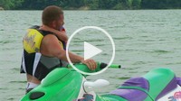 Father helps daughter get off jet ski.