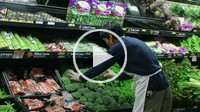 Man facing broccoli in grocery store.