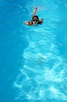 Girl 11 with goggles in swimming pool, Provence, France
