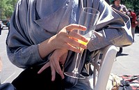 close up of a woman in high fashion at the races holding her glass of champagne and orange juice