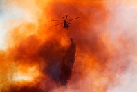 A helicopter drops water on a mountain fire  Table Mountain, Cape Town, South Africa