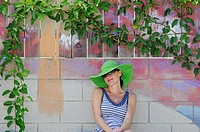 Woman sitting under painted tree with real leaves, Thousand Oaks, California, USA