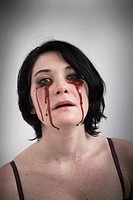 Woman with blood dripping from under her eyes