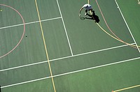 man playing tennis on tennis and basketball court