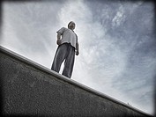 Challenging single man standing on a ledge.