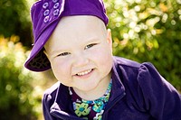 Portrait of a young girl with pediatric cancer leukaemia smiling at the camera  She has just lost her hair after a strong dose of chemo therapy but is...