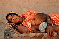 A hindu woman is sleeping while her baby is suckling. From a village in Thar desert, Rajasthan, India.