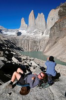 Hikers resting below the spectacular Torres del Paine, Torres del Paine National Park, Patagonia, Chile