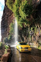 Taxi driving through waterfall at the old coastal road, also called the car washing street, Madeira, Portugal, Europe