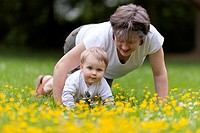 mom andtoddler son crawling through grass