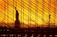 USA, New York, statue of the Liberty behind the Brooklyn bridge.