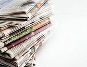 pile of old newspapers stacked on a white background