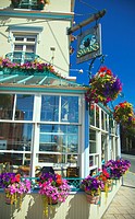 A view of the Swan Hotel in downtown Victoria showing hanging flower pots all around it