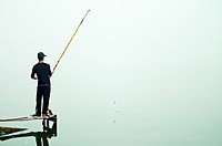 A lone fisherman at at West Lake in Hanoi, Vietnam