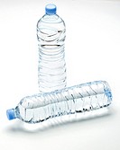 two plastic bottles unlabeled full of mineral water on white background