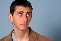 Teenage young man looking up with a worried expression