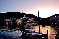 Cadaques at night with boat in foreground, Coast of a Mediterranean village at night with boat in foreground