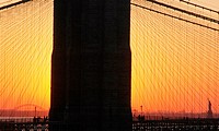 New York City, the Liberty Statue seen in the distance, at dusk, through the Manhattan Bridge