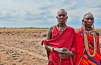 Kenya Africa Amboseli Masai man and woman in red costume dress and beads in Amboseli National Park safari out alone in jungle 1