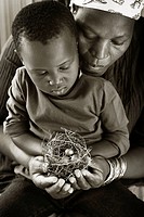Black mother with child looking at nest with egg
