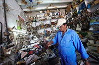 An indian mechanic repair a fridge component in a repair workshop  Ras Al-Khaimah  United Arab Emirates