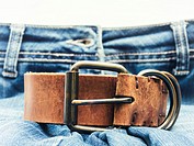 Jeans with brown leather belt in foreground