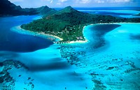 Aerial of the green water and clear blue colors of the islands of Bora Bora in Tahiti in French Polynesia