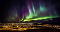 Aurora Borealis or Northern lights over Reykjavik and suburbs, Iceland