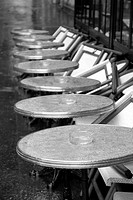 Row of wet round tables cafe terrace in Quay Branly Paris France