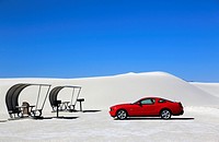 A red car with shaded picnic tables in the picnic area in White Sands National Monument. Alamogordo. New Mexico. USA.