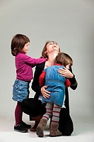 Woman with his two daughters in a hug.