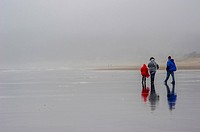 Family walking on rainy day on Cannon Beach.Cannon Beach,Oregon USA.