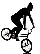 one caucasian man exercising bmx acrobatic figure in silhouette studio isolated on white background.