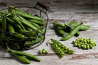 Pea Pods and Shelled Peas on Wooden Table.