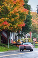 Vintage car driving through the picturesque town of Weston in the Indian Summer, Vermont, USA