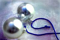 Two silver Christmas baubles on blue ribbon.