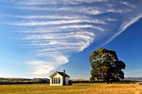 Farm house, tree and clouds, South Island, New Zealand.