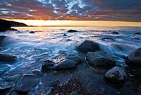 Sunset over rocky coast line, Sumner beach, Christchurch, New Zealand.