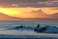 Surfersat sunset, The Pass, Byron Bay, New South Wales, Australia.
